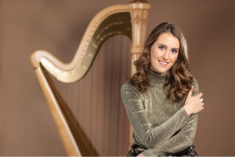 Picture of Esther Beyer in font of a big harp