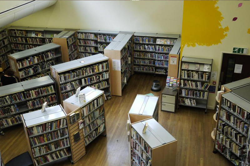 A library floor main space with book shelves dotted around.