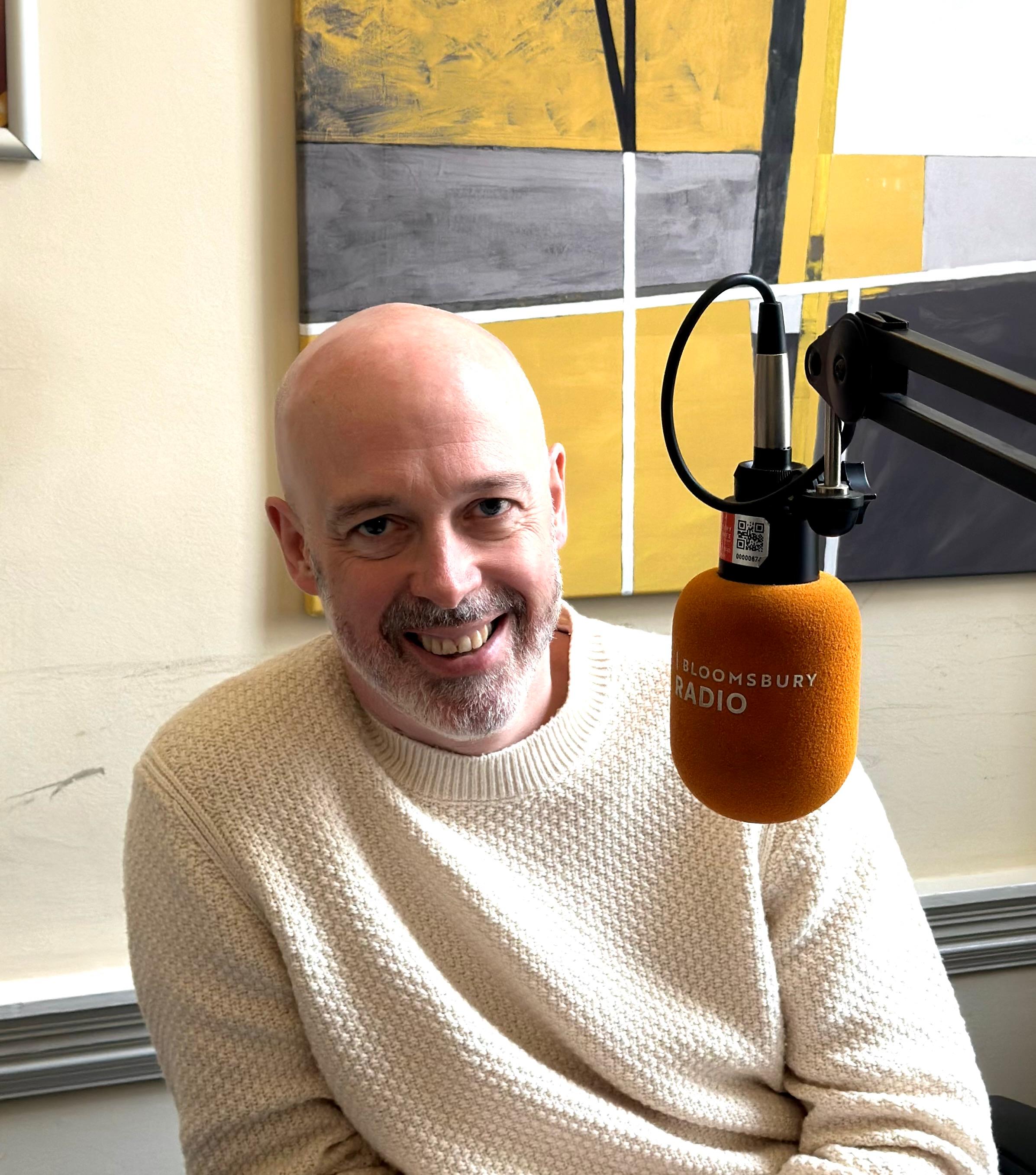 Person smiling next to a microphone